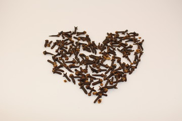 Heart-shaped dried cloves on a white background