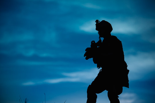 Silhouette of military soldier or officer with weapons at night.