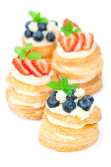 homemade puff pastry stuffed with cream and berries on white