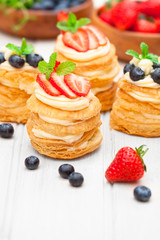 homemade puff pastry stuffed with cream and berries on white tab