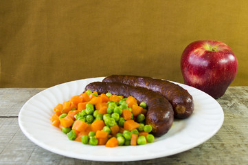 Sausages on a plate and fruits