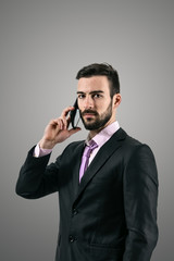 Dramatic portrait of young businessman on mobile phone