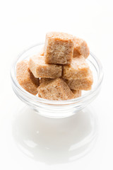 Rushy raw sugar cubes in the glass bowl