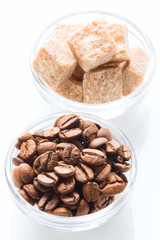 Roasted coffee beans and raw sugar cubes