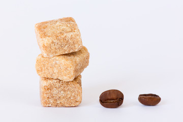 Isolated raw brown sugar cubes and coffee beans