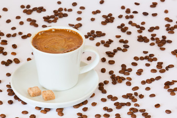 Fresh brewed coffee mug with sugar cubes and coffee beans