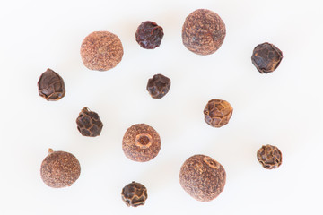 Isolated allspice and black peppers still life