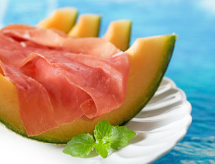 prosciutto and melon garnished with mint leaf