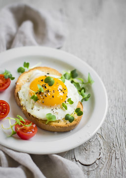toast with egg on a white plate on a light surface