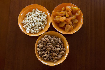 almonds and peanuts with dried apricots in bowls