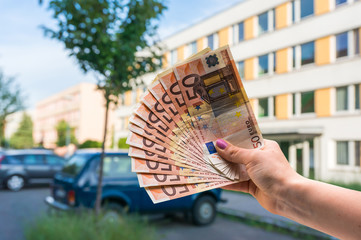 Property buyer holding euro banknotes and buying beautiful flat