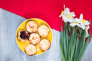 cheesecakes on yellow plate  with fresh narcissus top view 