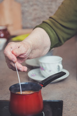 Fototapeta na wymiar Older lady making coffee