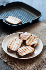 Crostini with fried cheese on the grill