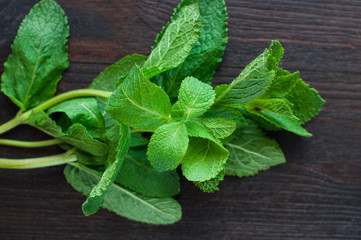 fresh mint leaves on the wooden background © Titarenko