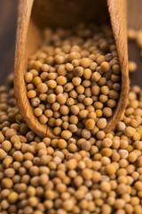 Spicy mustard seeds in a wooden background