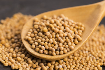 Spicy mustard seeds in a wooden background