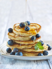 Stack of pancakes with fresh blueberry and honey