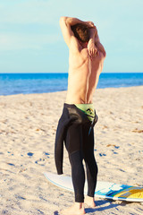 Surfer reaching for his zipper string