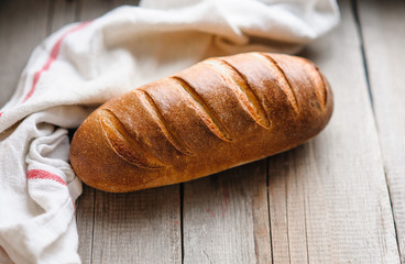 baked homemade bread on rustic light wood background