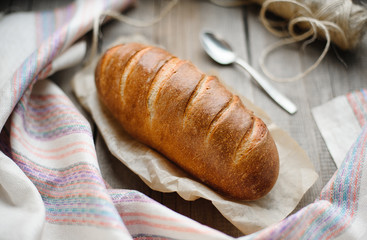 baked homemade bread on rustic light wood background