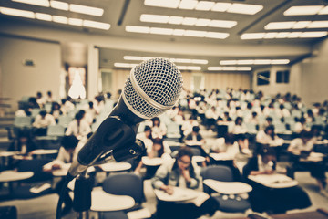 A microphone with blur background of many students learning
