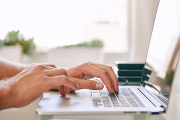 Close-up of hands busy working on a laptop, with copy space