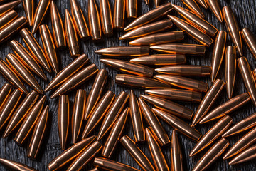 Placer copper bullets on a dark wooden background