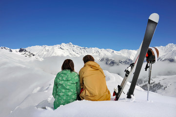 Skifahrer sitzen vor traumhafter Bergkulisse