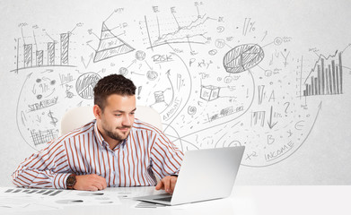 Business man at desk with hand drawn charts