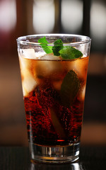 Glass of cocktail in bar on bright blurred background