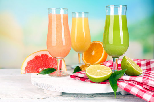 Fresh summer cocktails on wooden table on bright blurred background