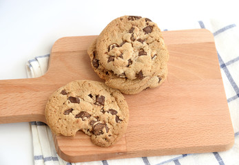 close up of home made chocolate chip cookies on a wooden plate