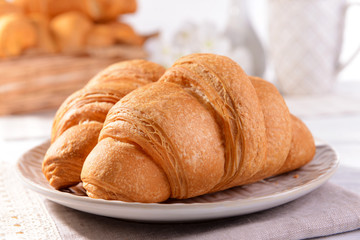 Delicious croissants on plate on table close-up