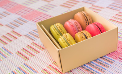 Sweet and colourful french macaroons on cotton cloth background.