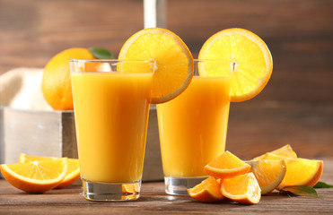 Fototapeta na wymiar Orange juice on table on wooden background