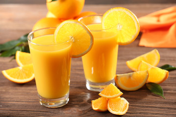 Fototapeta na wymiar Orange juice on table on wooden background