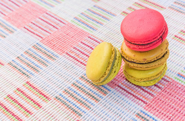 Sweet and colourful french macaroons on cotton cloth background.