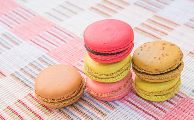 Sweet and colourful french macaroons on cotton cloth background.