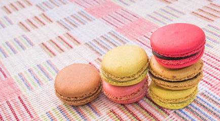 Sweet and colourful french macaroons on cotton cloth background.
