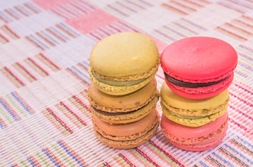 Sweet and colourful french macaroons on cotton cloth background.