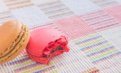 Sweet and colourful french macaroons on cotton cloth background.