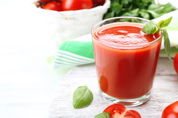 Glass of fresh tomato juice on wooden table, closeup
