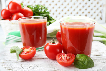 Glasses of fresh tomato juice on wooden table, closeup