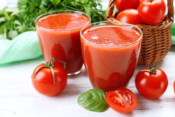 Glasses of fresh tomato juice on wooden table, closeup