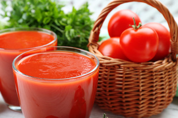 Glasses of fresh tomato juice on wooden table, closeup