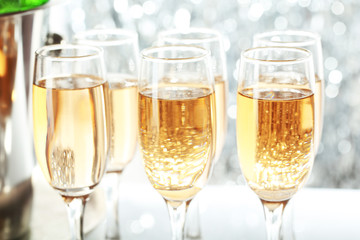 Glasses of champagne on bright background