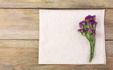 Beautiful dry flowers on napkin on wooden background