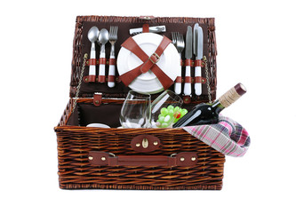 Wicker picnic basket with food, tableware and tablecloth isolated on white
