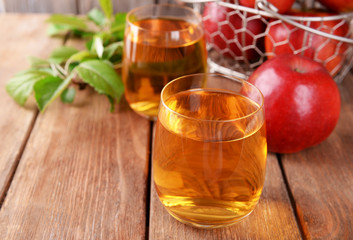 Glasses of apple juice on wooden table, closeup